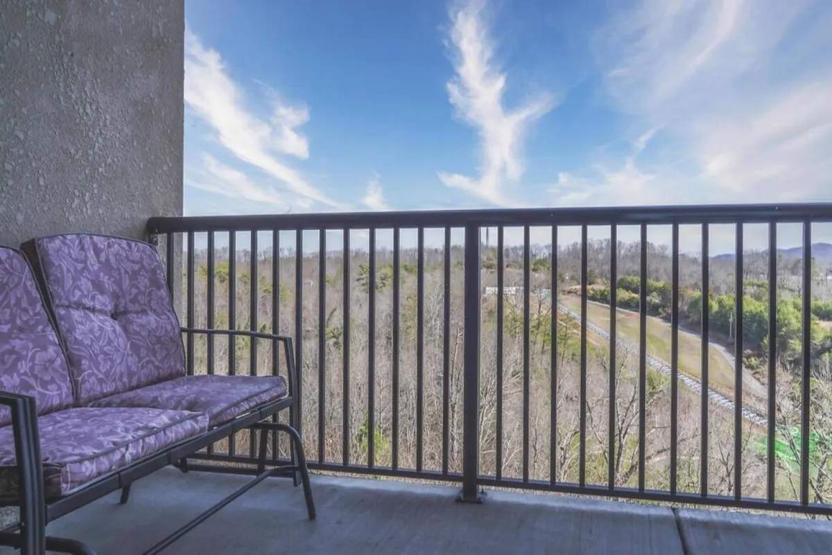 This exterior image captures a private balcony with comfortable seating, set against a backdrop of dramatic mountain views and a sky with beautiful cloud patterns. The tranquil setting is perfect for unwinding while immersed in nature's grandeur.